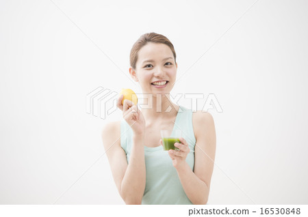 A woman drinking vegetable juice 16530848