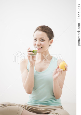 A woman drinking vegetable juice 16530855