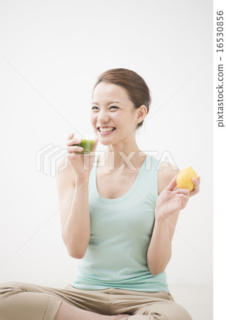 A woman drinking vegetable juice 16530856
