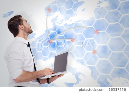 Composite image of sophisticated businessman standing using a la 16537556