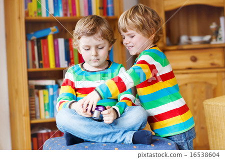 Two little siblings kid boys  making photos with photocamera, in 16538604