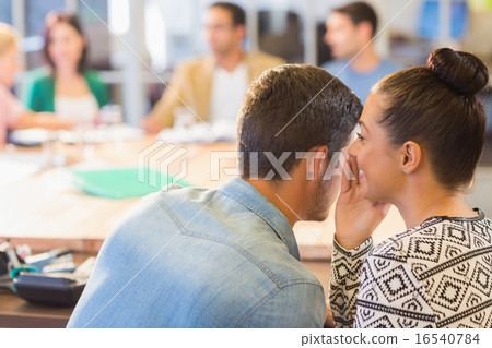 Casual businesswoman whispering secret to her colleague Casual businesswoman whispering secret to her colleague 16540784