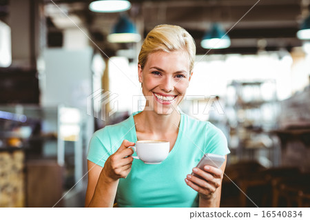 Pretty blonde woman using her smartphone 16540834