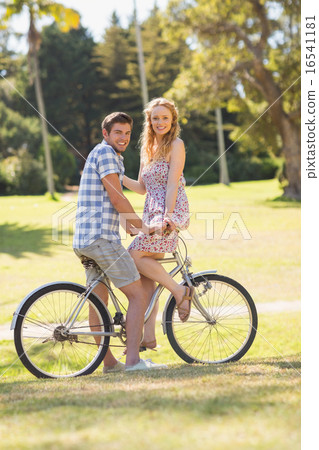 Young couple on a bike ride looking at camera 16541181