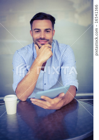 Smiling businessman using a tablet Smiling businessman using a tablet 16541366