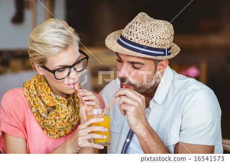 Cute couple on a date sharing an orange juice Cute couple on a date sharing an orange juice 16541573