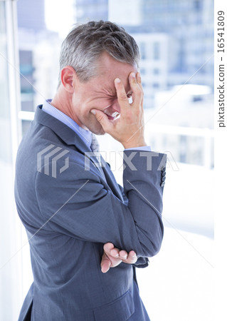 Troubled businessman holding his head 16541809
