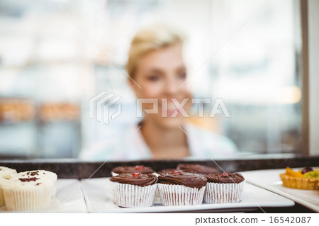 Pretty woman looking at cup cakes 16542087