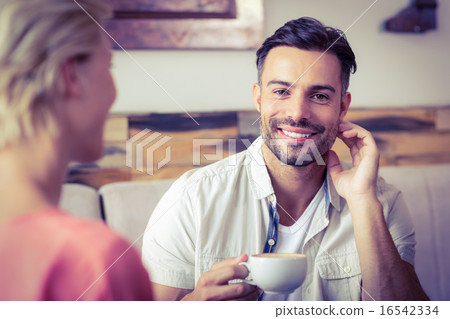 Couple with coffee cup sitting on sofa 16542334