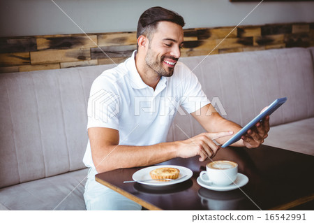 Young man having cup of coffee and pastry Young man having cup of coffee and pastry 16542991