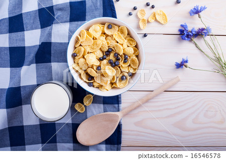 cornflakes with bilberry, milk cup , flower and spoon cornflakes with bilberry, milk cup , flower and spoon 16546578