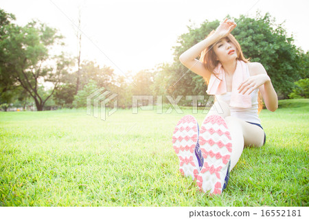 asian woman are tired sitting on the lawn. 16552181