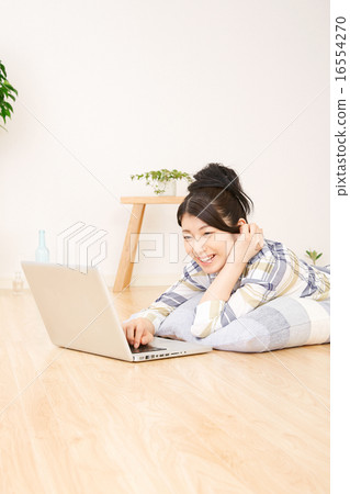 A woman using a laptop computer in the room 16554270