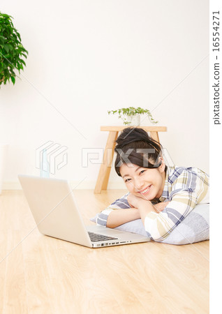 A woman using a laptop computer in the room 16554271