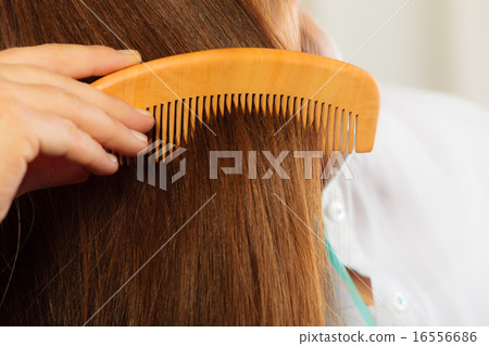 Closeup hair and hand with comb 16556686