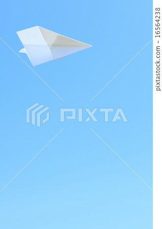 A paper plane dancing in a crystal clear blue sky 16564238