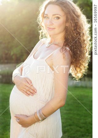 Beautiful pregnant woman relaxing in the park Beautiful pregnant woman relaxing in the park 16569997