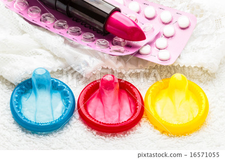 Pills condoms and lipstick on lace lingerie 16571055