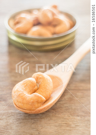 Cashew nut roast salt on weathered wooden table 16586501