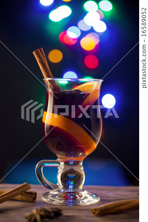Glass with mulled wine on dark bokeh background 16589052