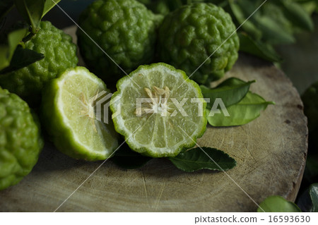 Kaffir lime cut in half on a wooden cutting board 16593630