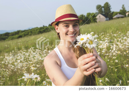 Beautiful woman enjoying daisy in a field Beautiful woman enjoying daisy in a field 16600673