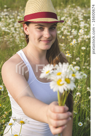 Beautiful woman enjoying daisy in a field Beautiful woman enjoying daisy in a field 16600674