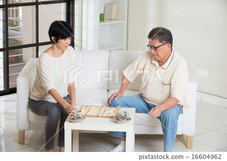 asian senior couple playing chess at home 16604962