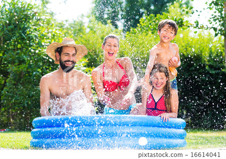 Family in garden pool cooling down splashing water Family in garden pool cooling down splashing water 16614041