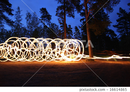 Fire spinning at night in forest 16614865