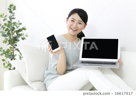A woman showing a screen of a notebook PC 16617817