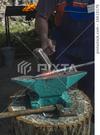 Blacksmith forges iron on anvil Blacksmith forges iron on anvil 16618176