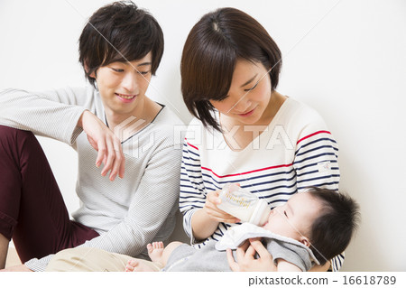 Dad raising milk to baby and mother 16618789