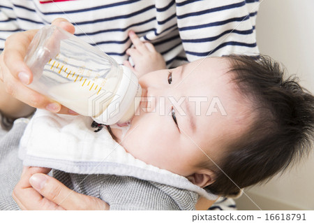 Dad raising milk to baby and mother 16618791