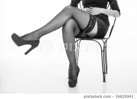 long slender female legs of girl sitting on a chair in black sto 16620941