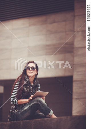 girl with tablet is walking in the downtown girl with tablet is walking in the downtown 16625471
