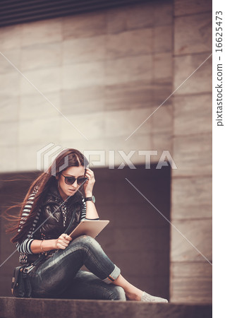 girl with tablet is walking in the downtown 16625473