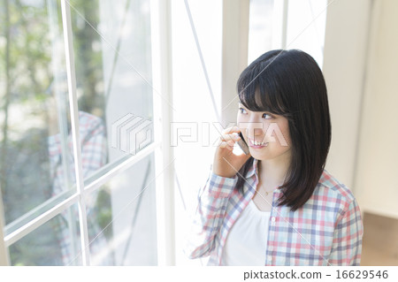 A woman talking on a smartphone A woman talking on a smartphone 16629546