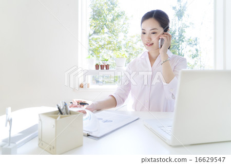A woman talking on a smartphone A woman talking on a smartphone 16629547