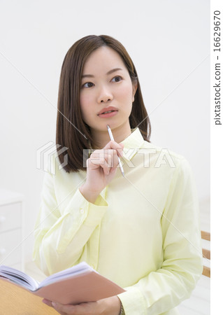 把筆放的婦女在她的下巴上 把筆放的婦女在她的下巴上 16629670