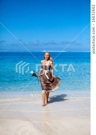 woman with a rose runs on the edge of the sea on a woman with a rose runs on the edge of the sea on a 16632602