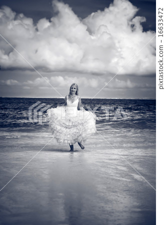 woman in a dress of the bride runs on waves of the 16633472