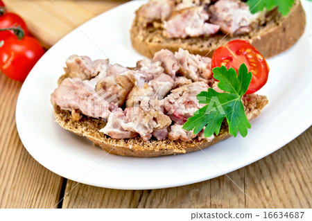 Sandwich with brains and tomato in plate on board 16634687