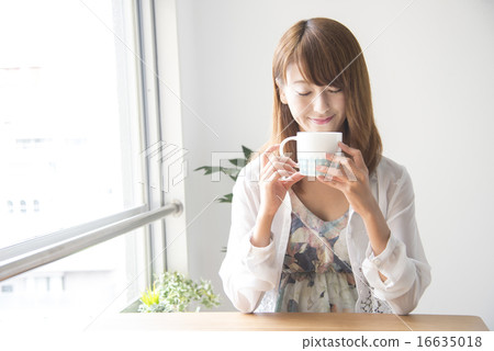 A woman with a cup of coffee in a cafe A woman with a cup of coffee in a cafe 16635018