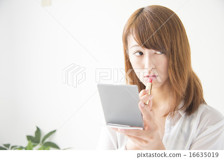 A woman applying lipstick A woman applying lipstick 16635019
