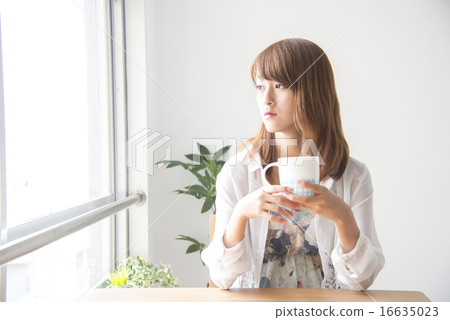 A woman with a cup of coffee in a cafe 16635023