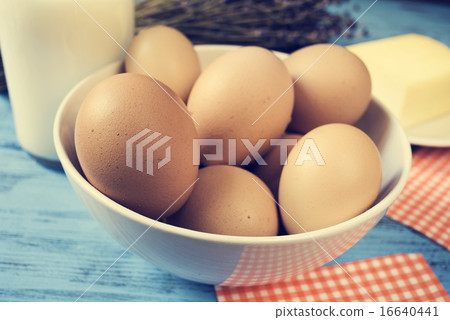 milk, eggs and butter on a blue rustic surface 16640441