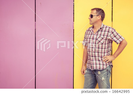 man looking away standing near the wall. man looking away standing near the wall. 16642995