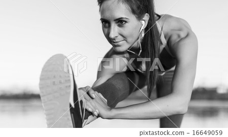 Fitness model athlete girl warm up stretching her hamstrings, leg and back. Young woman exercising 16649059