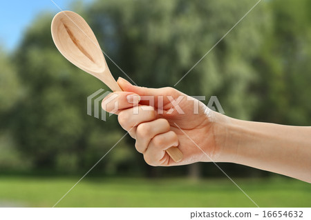 Wooden spoon in female hand Wooden spoon in female hand 16654632